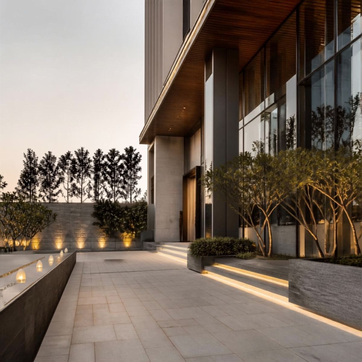 Landscaped building entrance with a lit pathway and trees