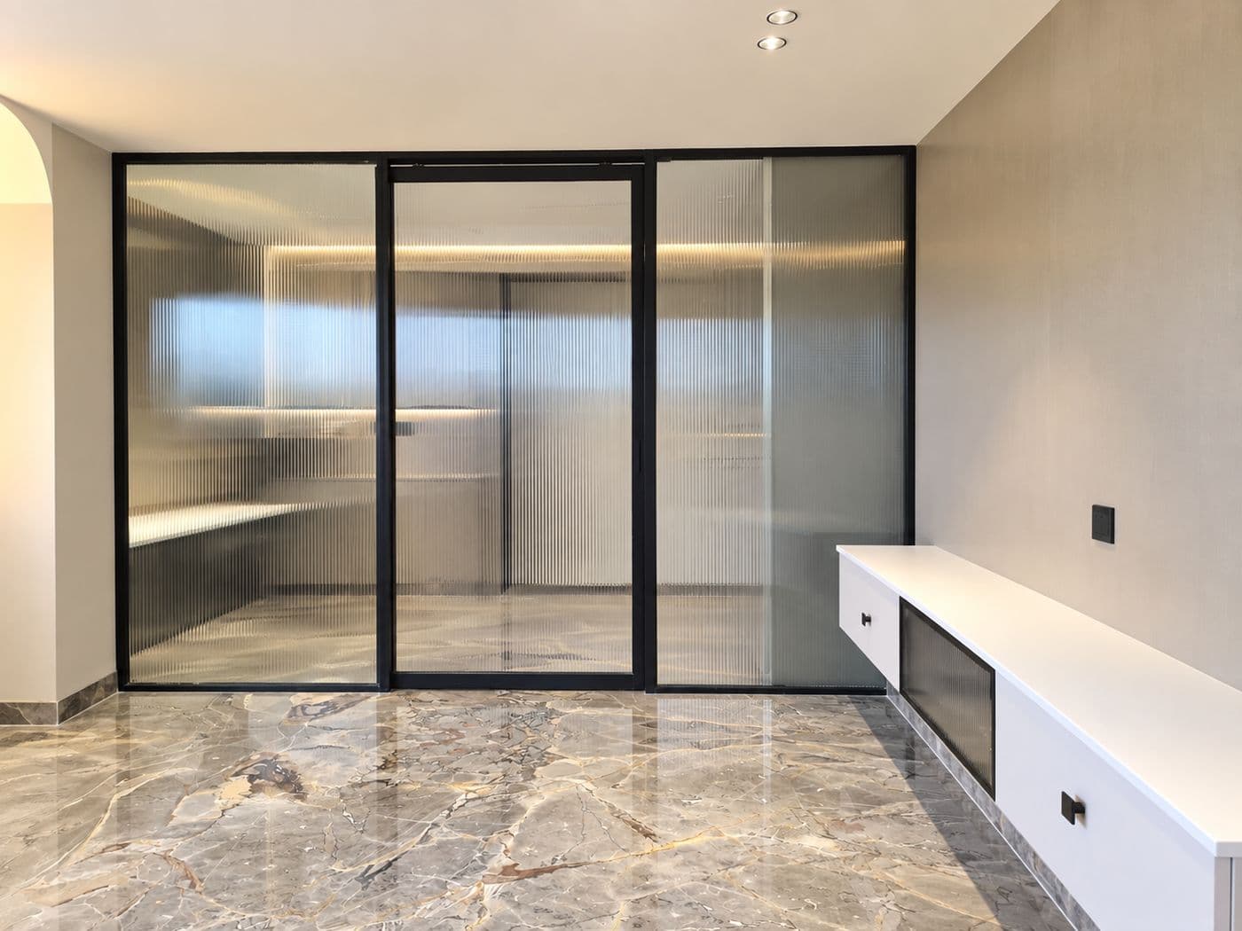 Villa room with a marble floor, glass partition and a white floating TV unit